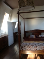 спальня с огромной кроватью, гардеробом, зеркалом и кондиционером